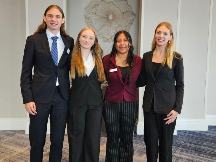 Four college students in business attire stand together at the Beta Alpha Psi Annual Meeting in Baltimore. Kaitlyn Niestoeckel is second from left with her Project Run With It teammates.