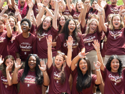 ������Ƶ Orientation Leaders cheering with arms raised, wearing maroon 'Orientation Leader' t-shirts.