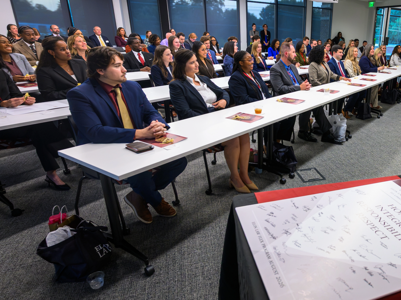 A large classroom with students seated in professonal dress.