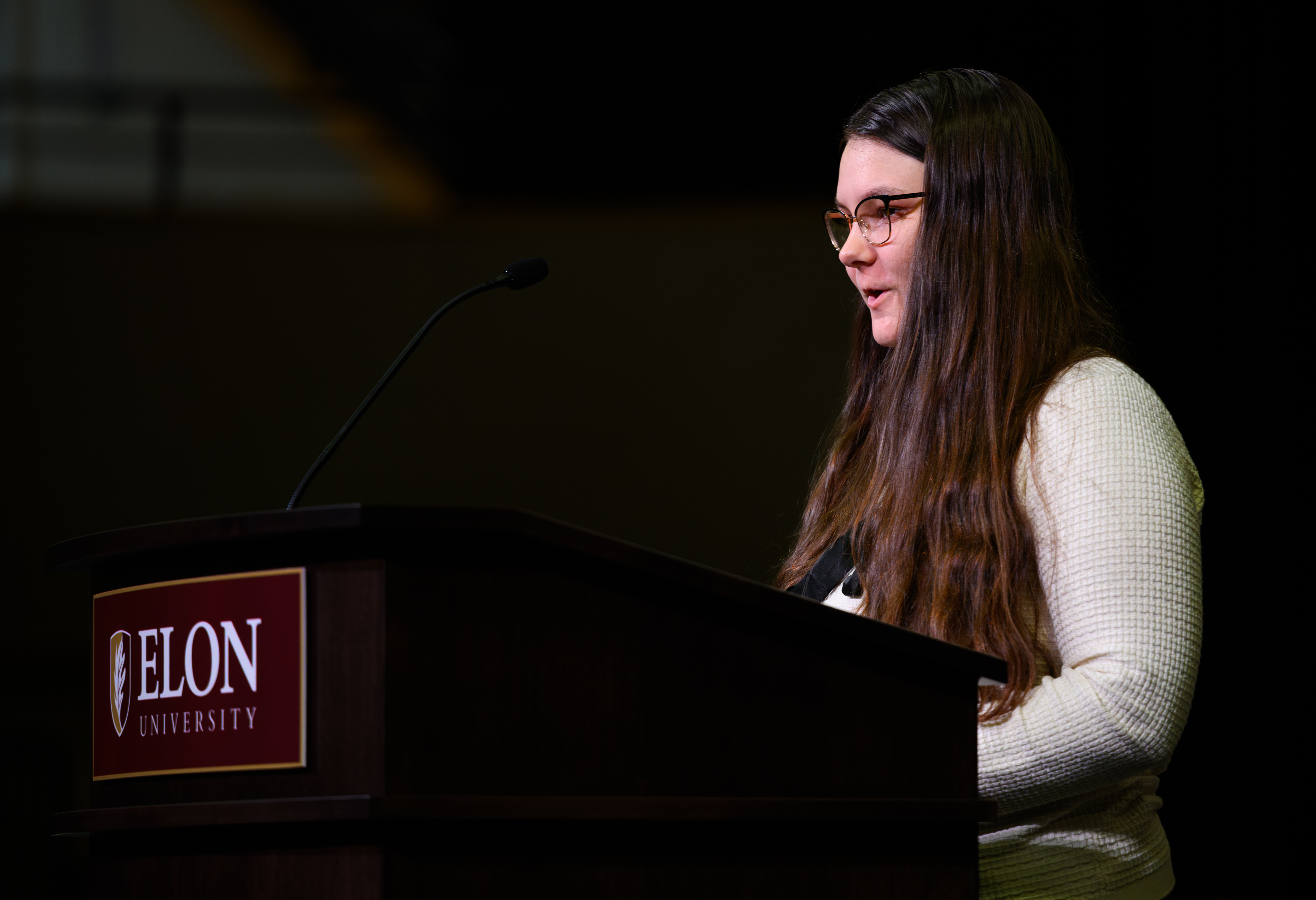 A student speaks at a podium during ������Ƶ’s Call to Honor ceremony as university leaders and students sit behind him onstage.