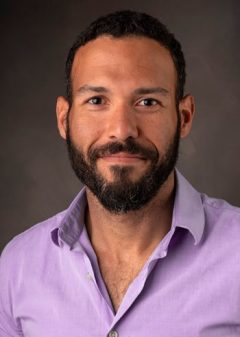 Headshot of Efrain Rivera-Serrano wearing a pink button up shirt. 