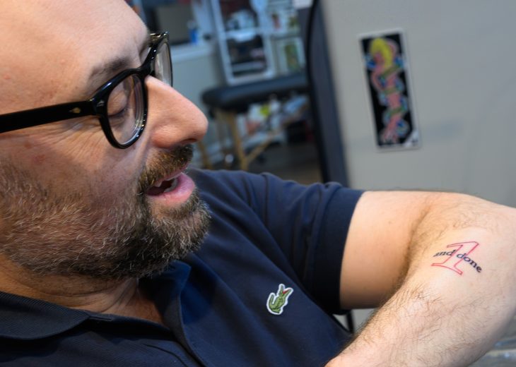 Zak Kramer looks at the One and Done tattoo on his left arm.