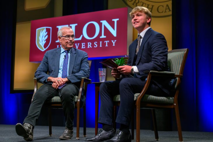 David Brooks sits beside an Elon student onstage during a question-and-answer session following his Fall Convocation address.