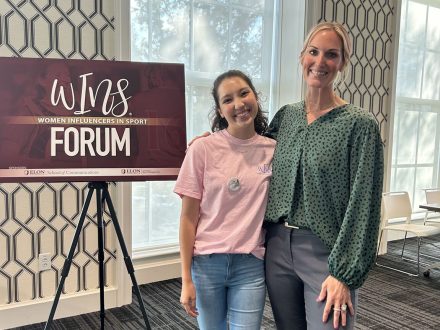 Two women stand at Women Influencers in Sport (WINS) initiative event.