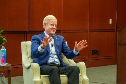 David Taylor gestures with both hands while speaking from a chair in LaRose Digital Theatre.