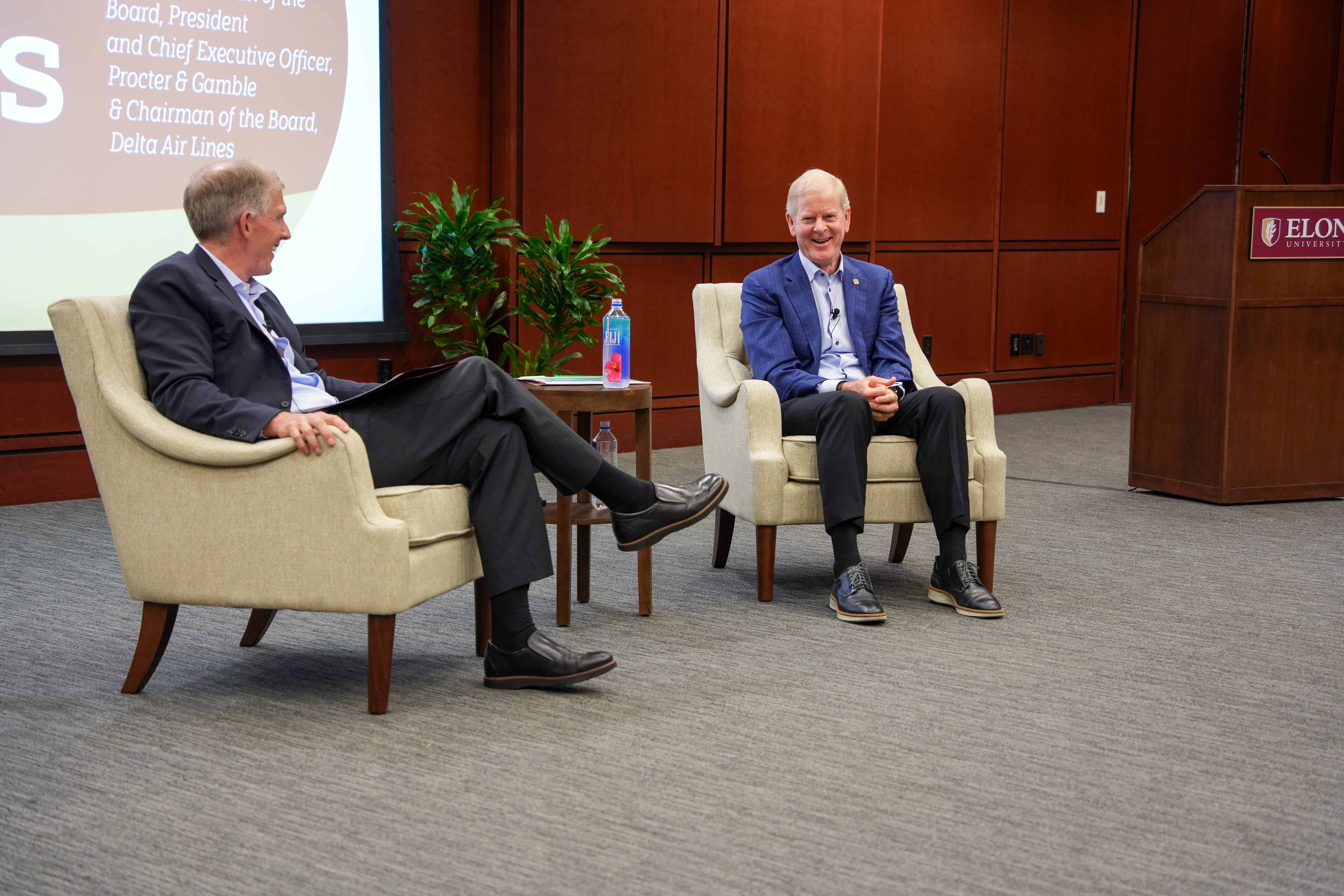 Jack Ryan and David Taylor smile and laugh while seated onstage.