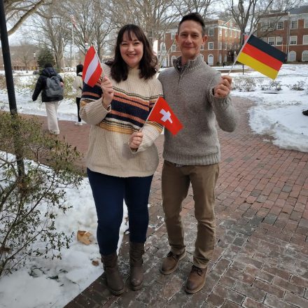 Two German Studies faculty members standing holding German flags.