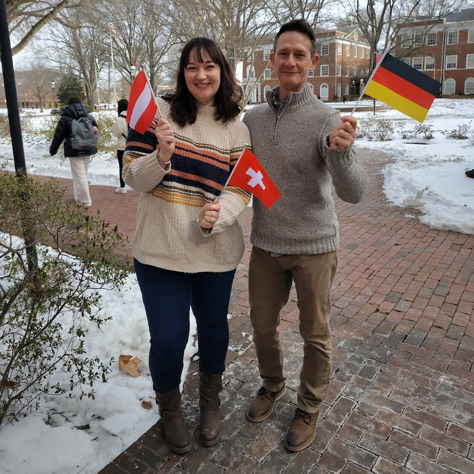 Two German Studies faculty members standing holding German flags.