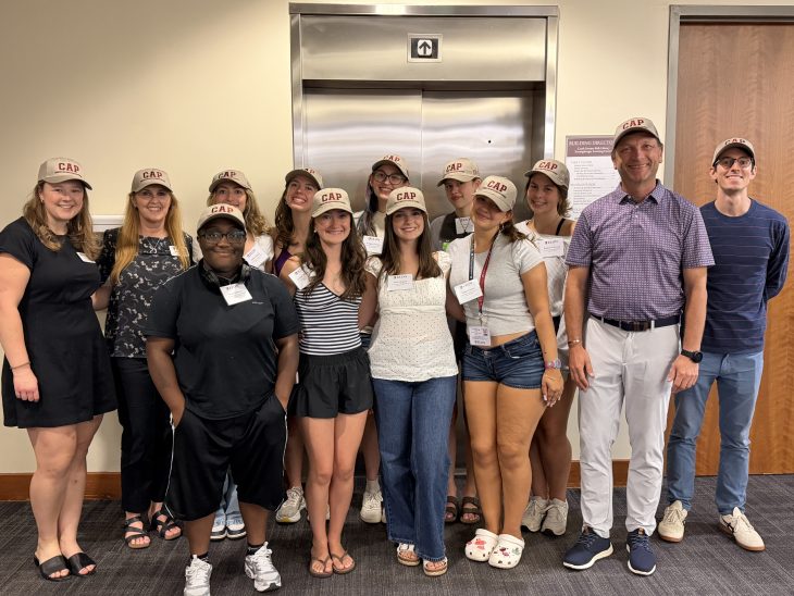 A group of people pose for a photo in front of an elevator