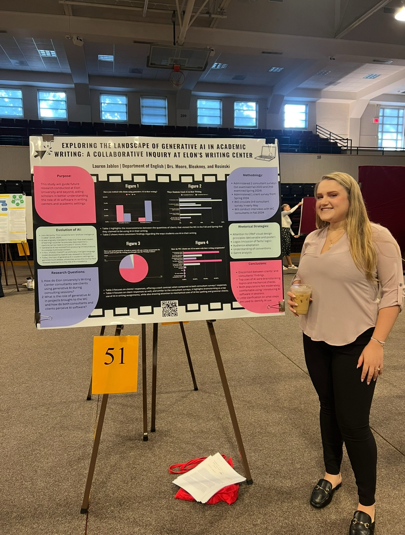 A student smiles while standing beside a research poster exploring the use of generative AI in academic writing at Elon University’s Writing Center.