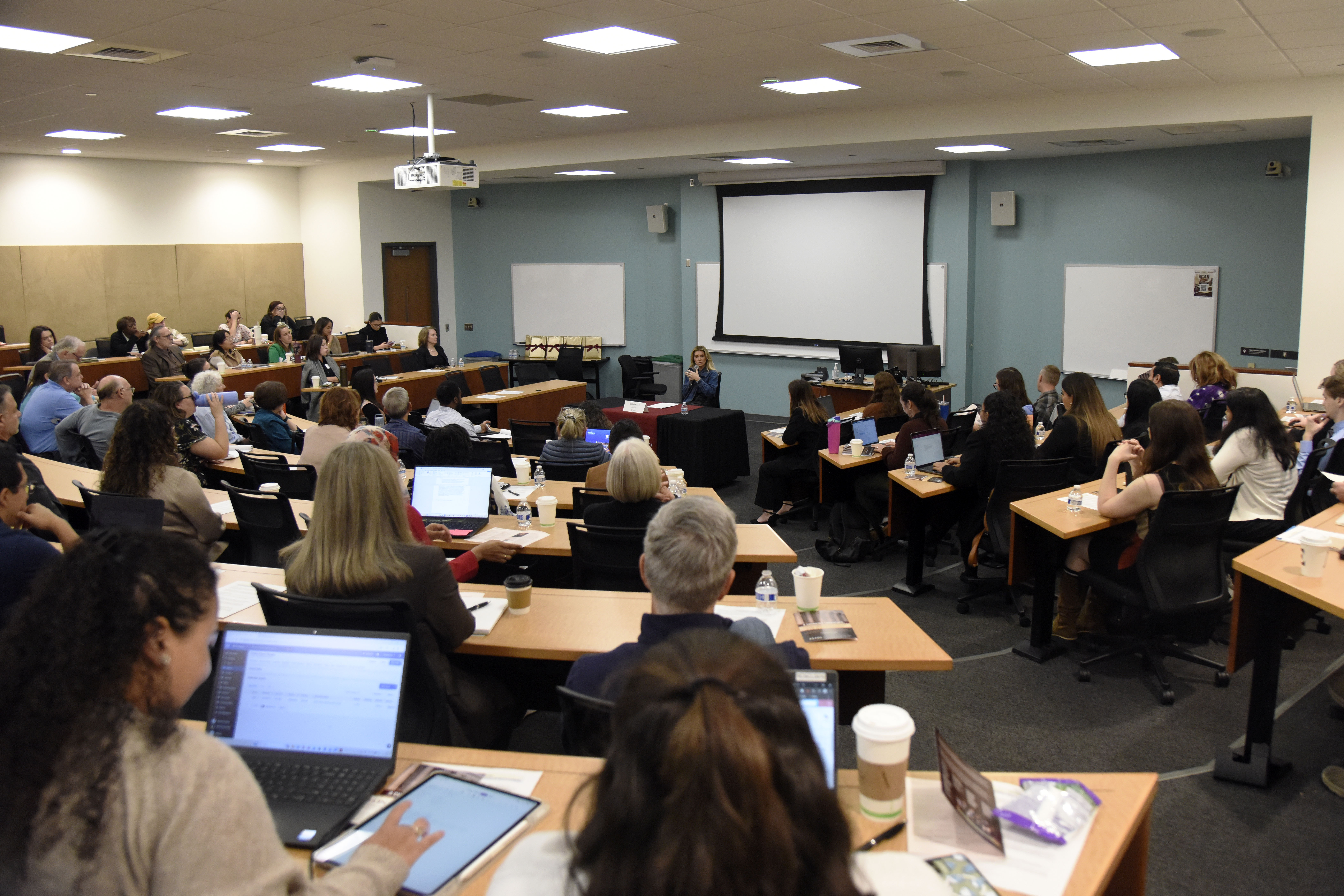 A photo of a classroom full of lawyers and students listening to a keynote speaker in front of the room at Elon University School of Law in Greensboro. The speaker is immigration attorney Hillary Walsh.
