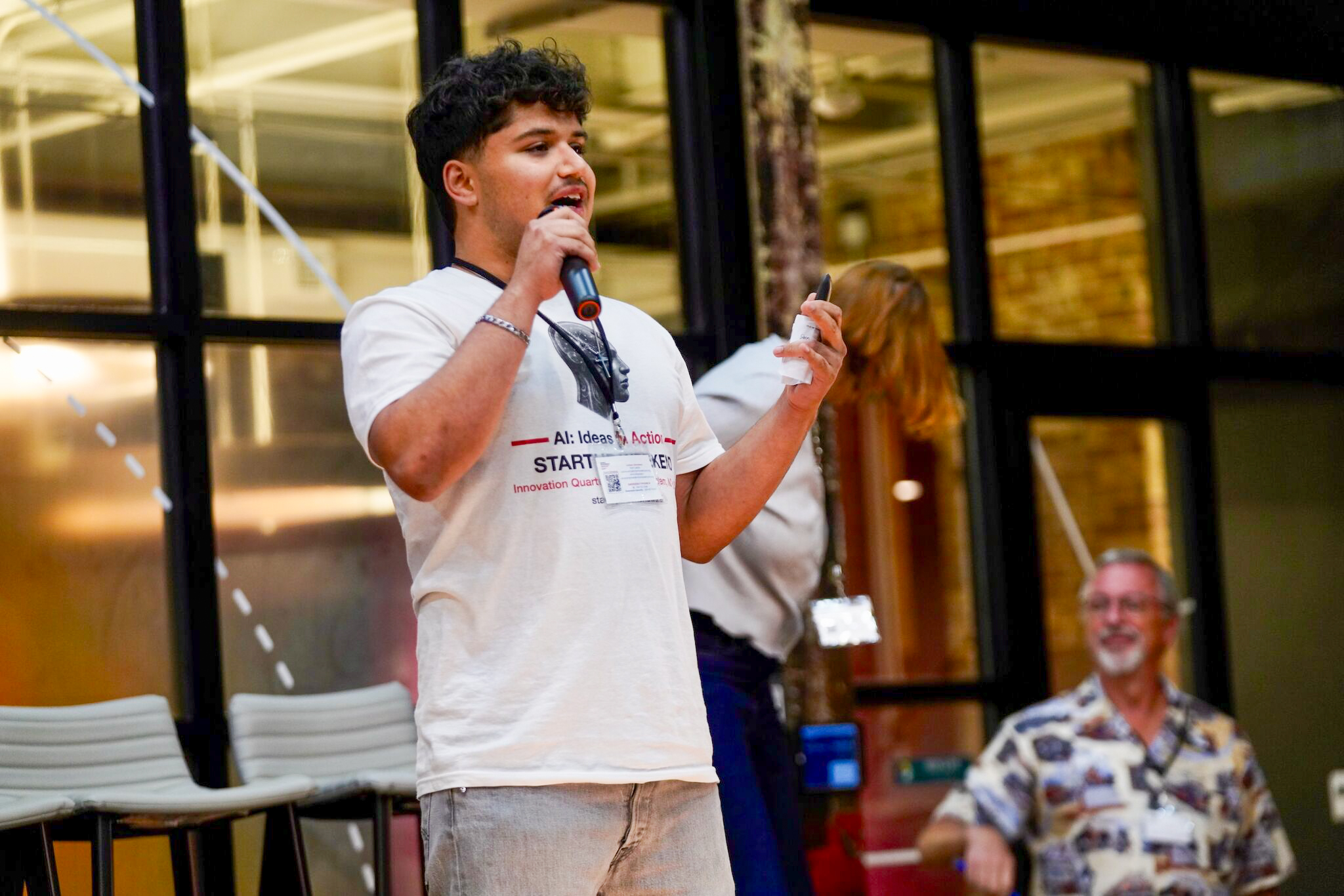 Jorge Sanchez ’30 speaks into a microphone while presenting his Trip Pilot startup idea.