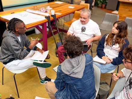 Members of the Transfer Ready team sit in a circle discussing their startup idea during a working session.