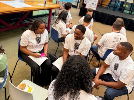 Kathy Atwiine ’29 sits with several teammates during a small-group discussion.