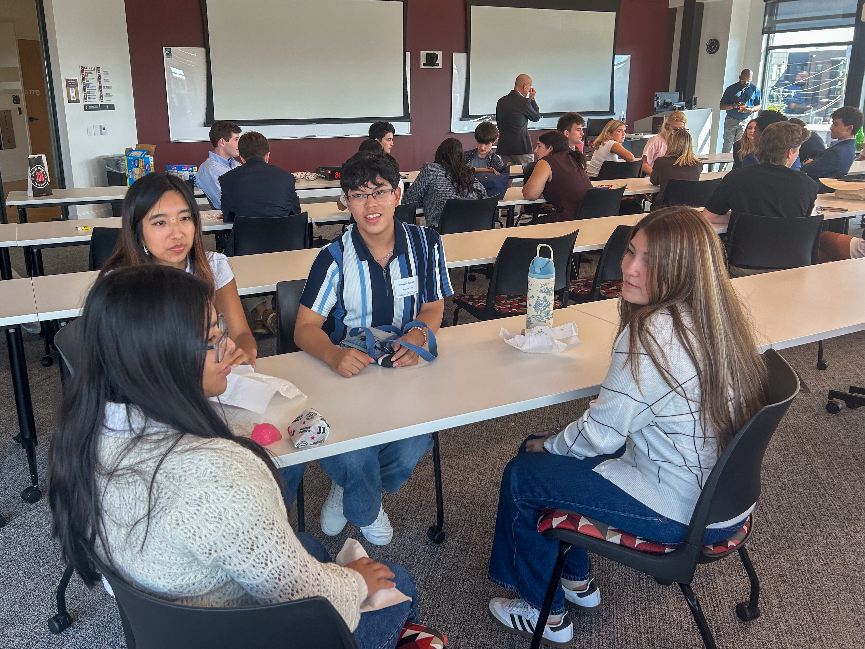 Elon students sit in small groups and talk with one another
