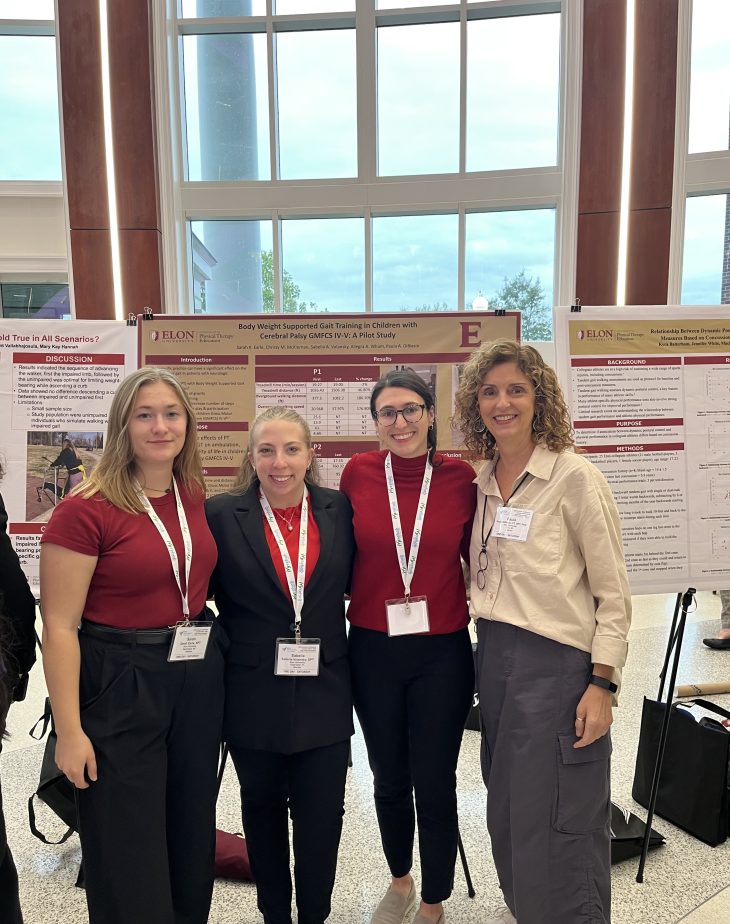 Group posing before their poster