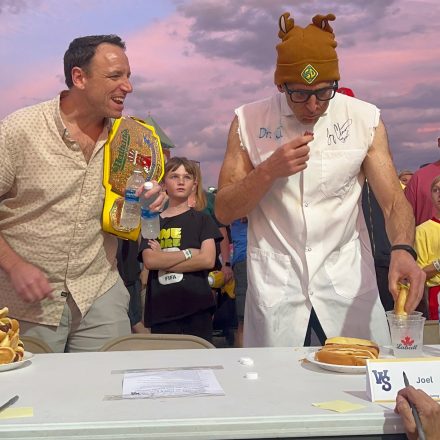 Joey Chestnut cheering Joel Karty on during the hot dog eating contest.
