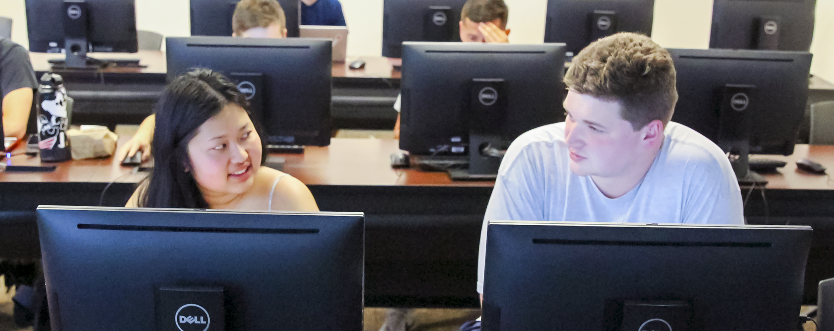A male and female student work together in a computer lab