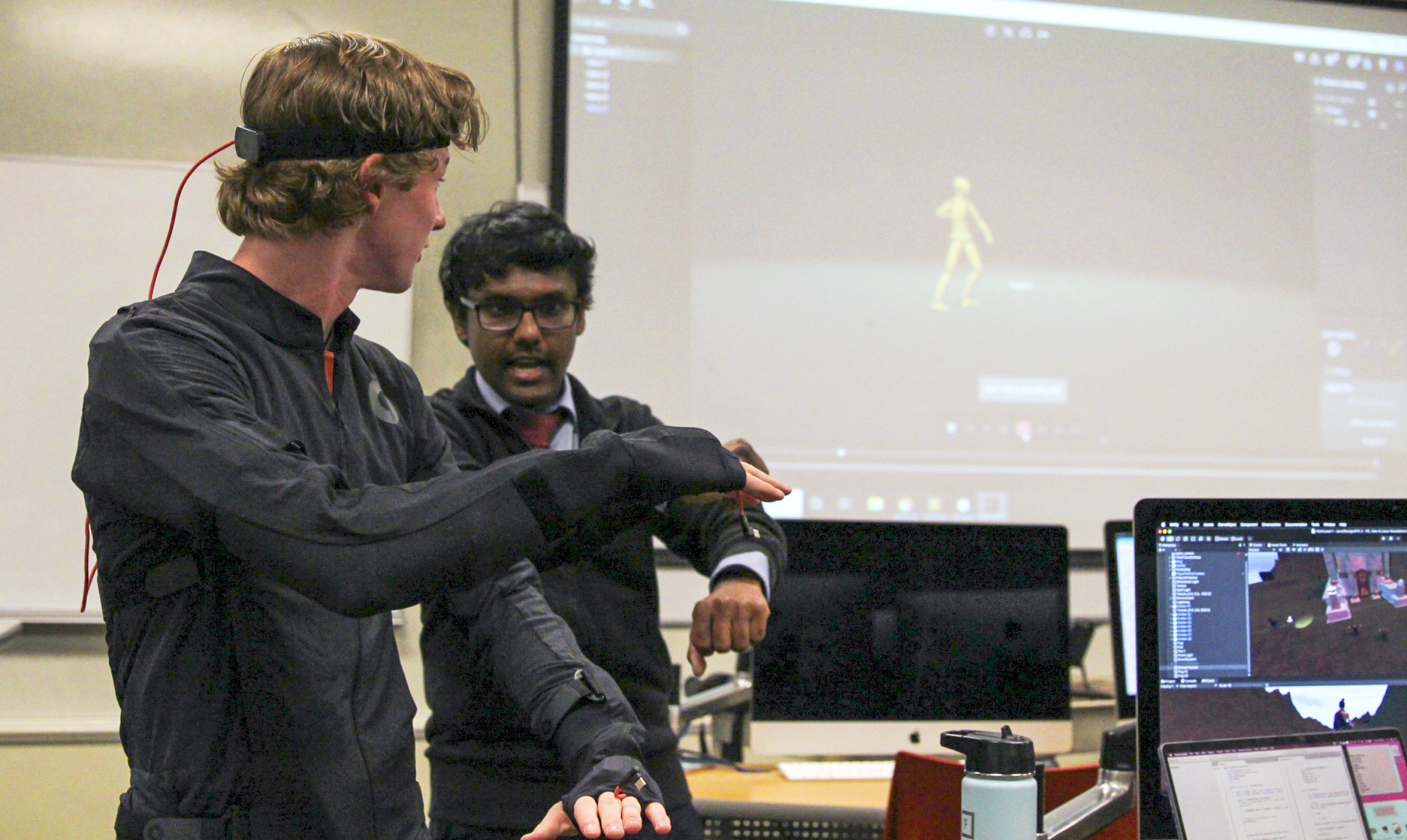 Assistant Professor Pratheep Paranthaman coaches a student wearing a motion-sensing body suit for a game design course.