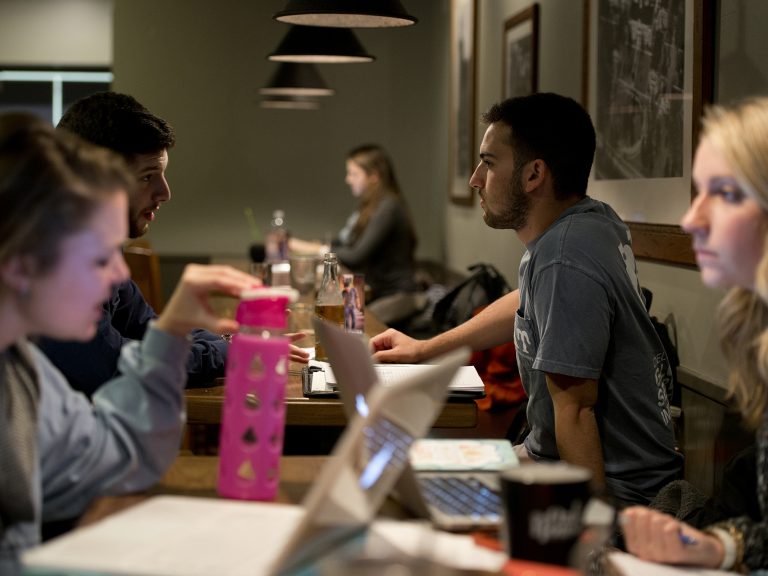 Two female students and two male students studying inside a coffee shop