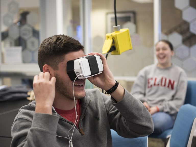A male student wearing virtual reality glasses