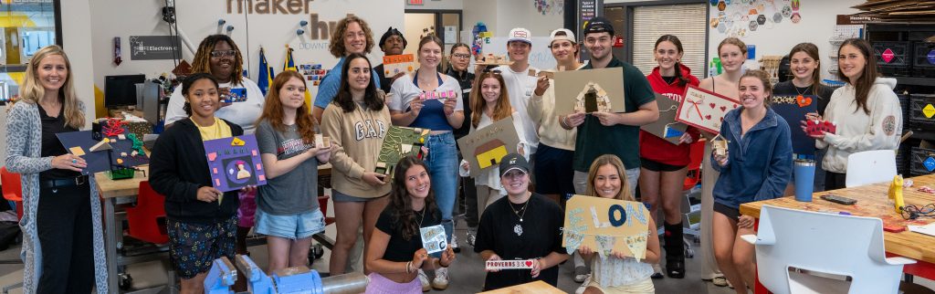 Group of student holding various projects.