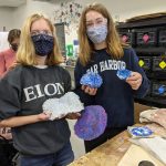 Students holding their flat sheets of melted plastic