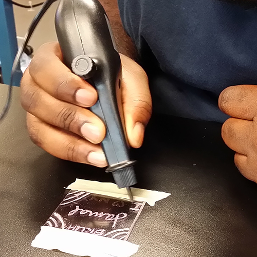 Student engraving plastic with dremel