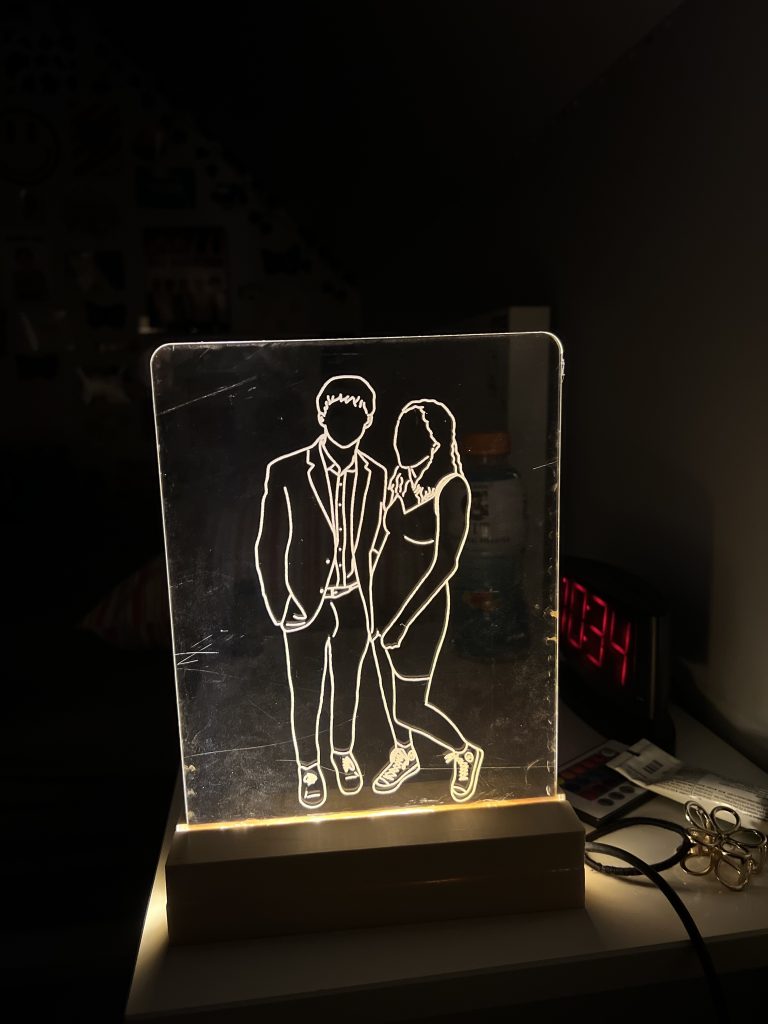 Light up sign with a couple close to each other