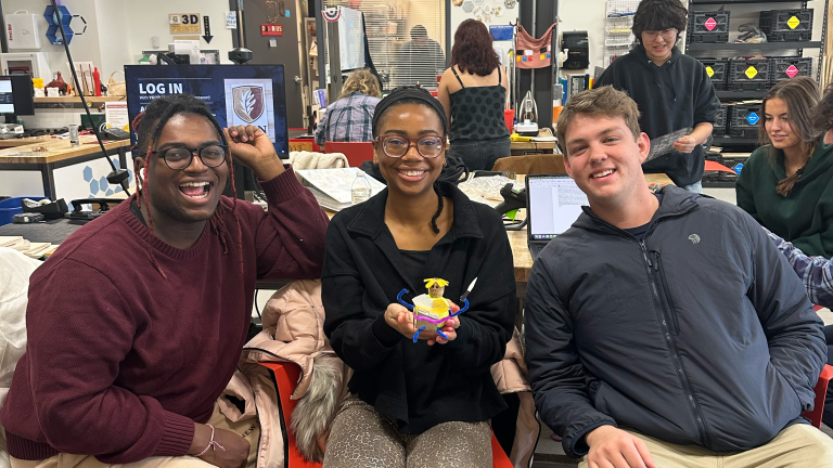 3 students holding the object they created.