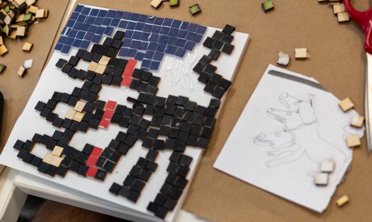 A student made mosaic with a 3 headed monster