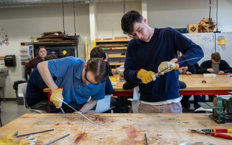 Students wraping wire around rods to make the springs.