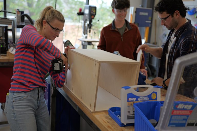 Students drilling joints into plywood box