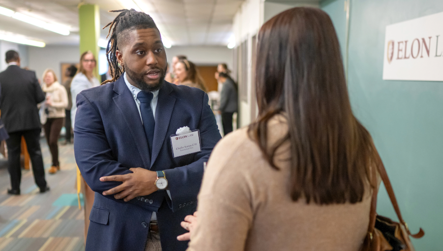 A man and woman speak inside Elon Law's Small Business Clinic. PreLaw Magazine names Elon Law is one of the best law schools in NC for practical training.