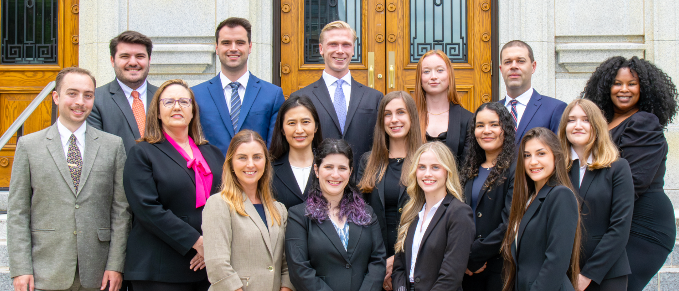 A group of professionally dressed Elon Law students at the Old Guilford County Courthouse
