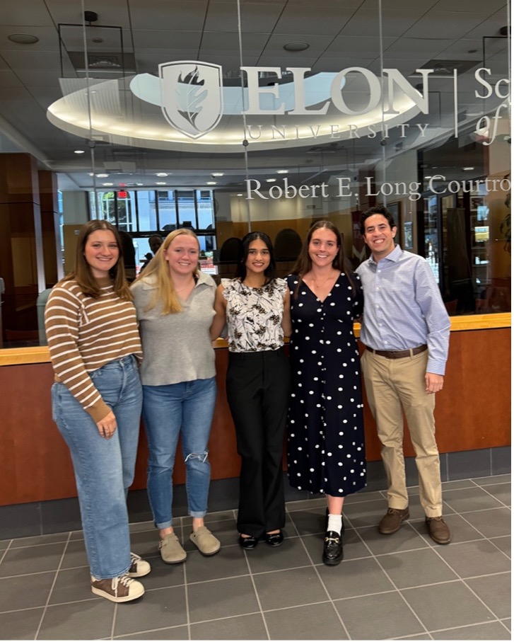 First generation society leadership, five students, in front of the Robert E Long Courtroom in Elon Law.