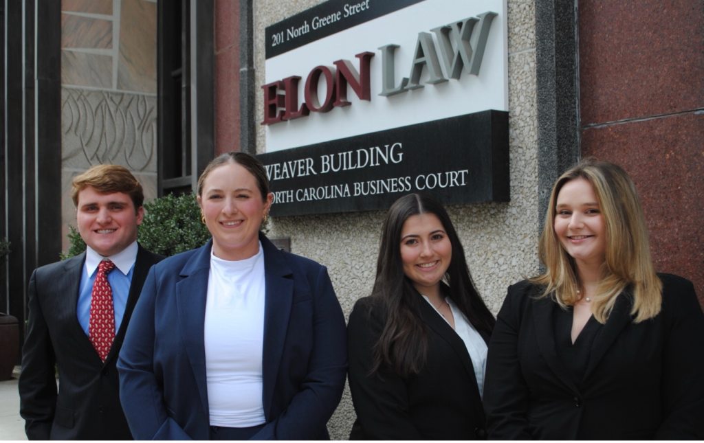 A group of students standing in front of the Elon Law building