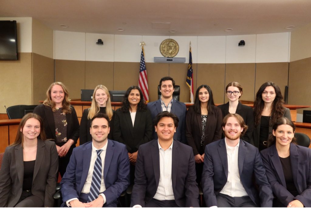 A group of people standing in the Elon Law Business Court