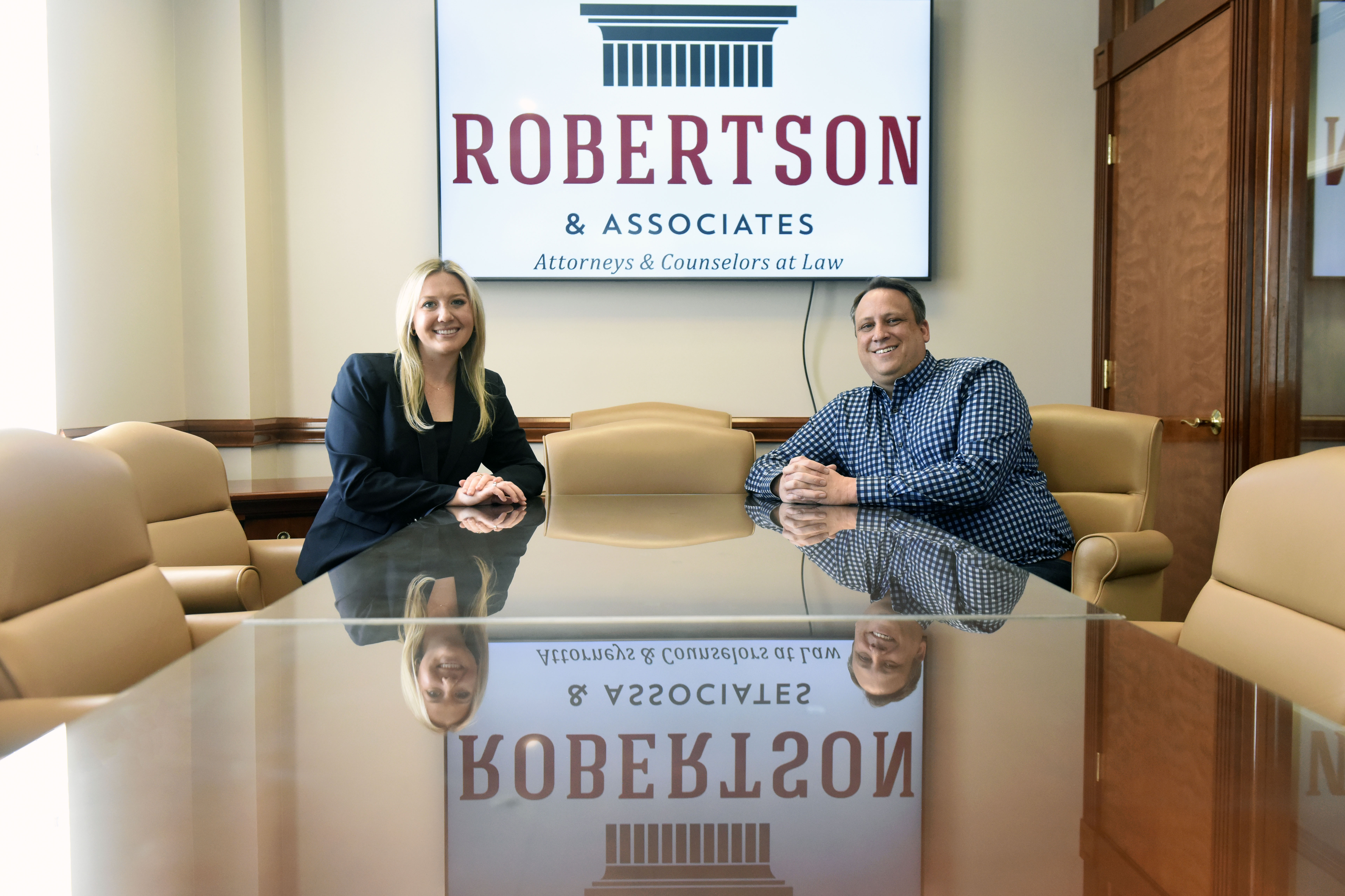 Sydney Rimmer L'24 and R. Lee Robertson Jr. seated in a conference from of Robertson & Associates law firm.