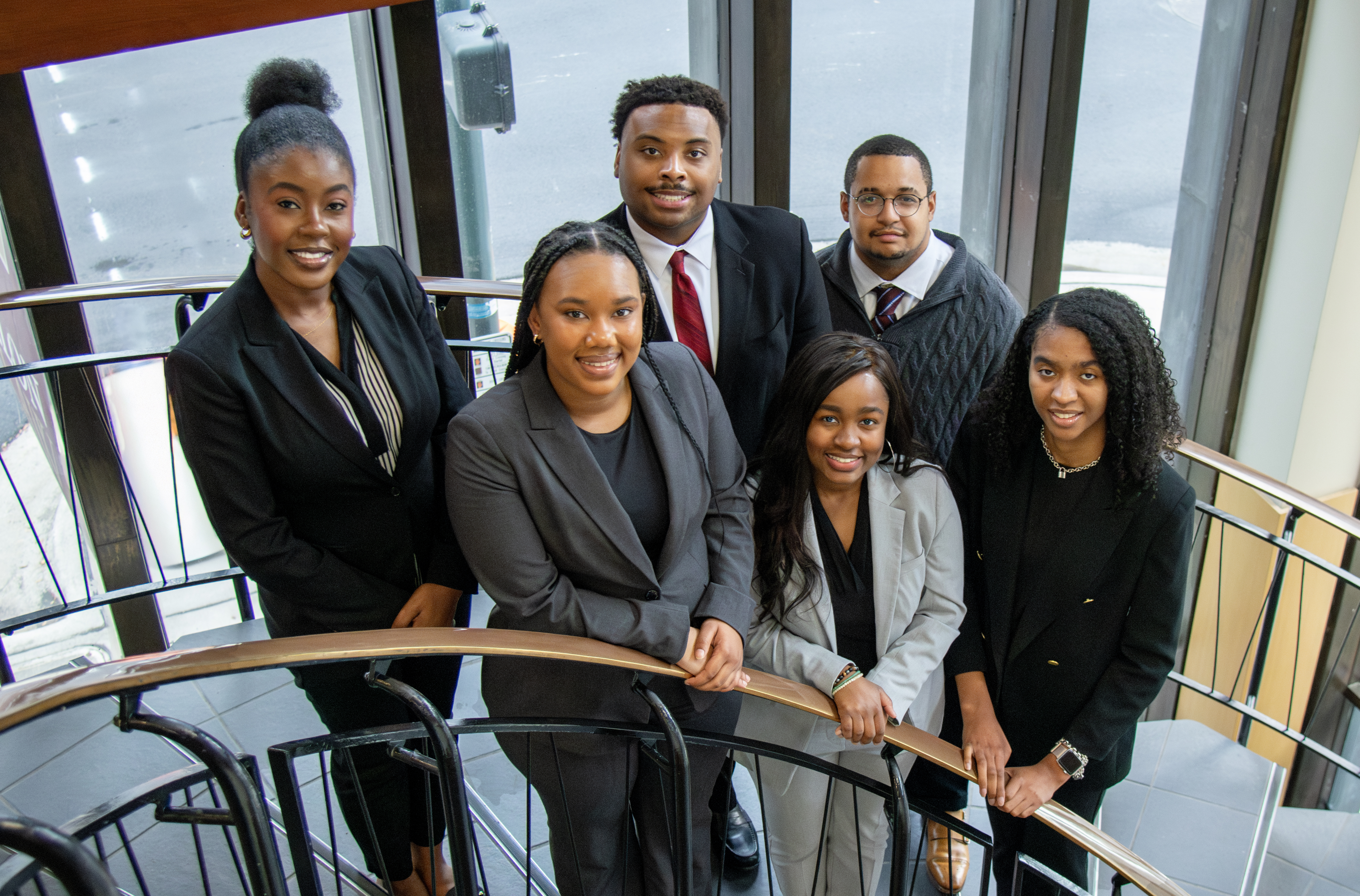 Six Elon Law students on a spiral staircase in the lobby