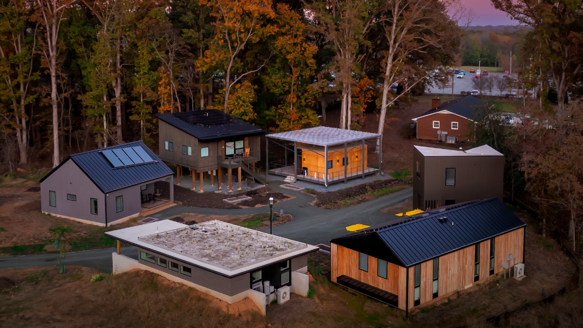 Six small homes on the edge of Loy Farm at Elon University, pictured in an aerial viewat sunset.